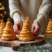 You placing a golden puff pastry Christmas tree on a festive holiday table surrounded by decorations.