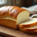 Freshly baked homemade sandwich bread sliced on a wooden board.